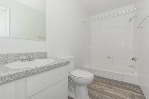 A white bathroom with a toilet, sink, and bathtub.