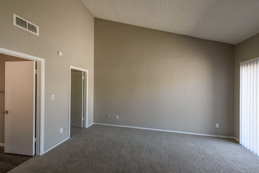 an empty living room with a door to a closet