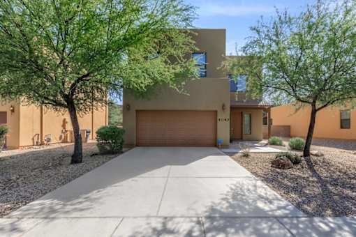 A modern house with a brown garage door and a driveway.