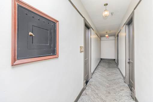 A hallway with a black door and a red frame.