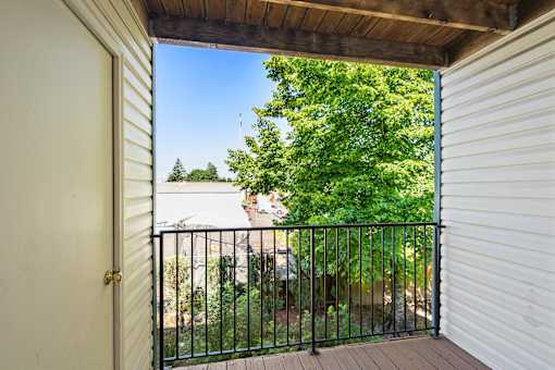 A view from a doorway looking out to a balcony with a black railing.