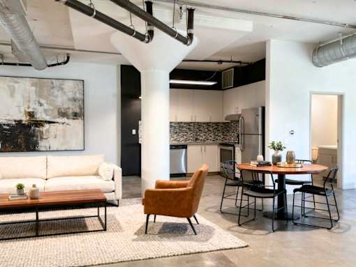 A modern living room with a large abstract painting on the wall.