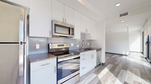 A modern kitchen with white appliances and cabinets.