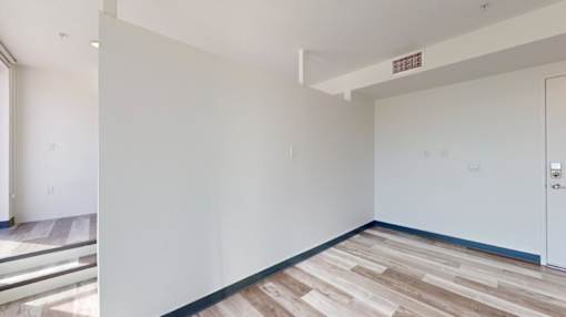 A room with a white wall and a door.