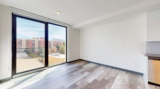 A room with a view of a building and trees outside the window.