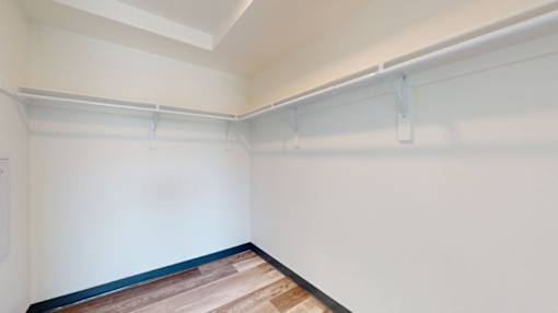 A room with a white wall and a wooden floor.
