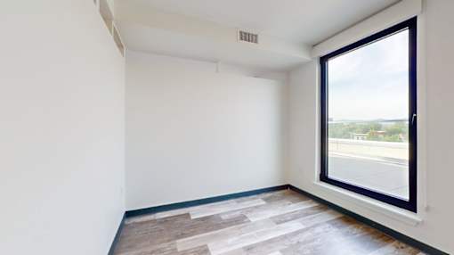 A room with a large window and a wooden floor.
