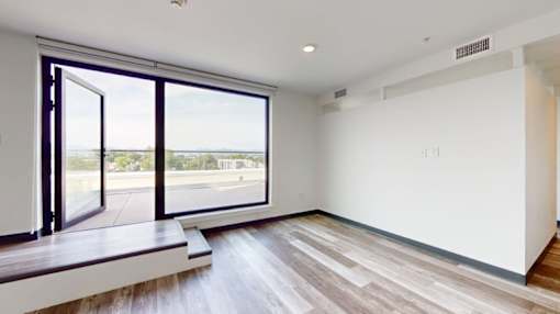 A room with a large window overlooking a street.