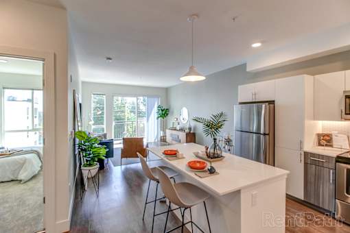 A kitchen with a white counter top and a refrigerator.