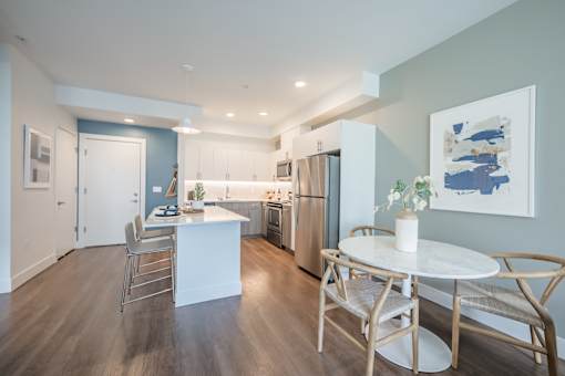A modern kitchen with a dining table set for two.