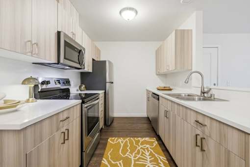 A kitchen with wooden cabinets and a black refrigerator.