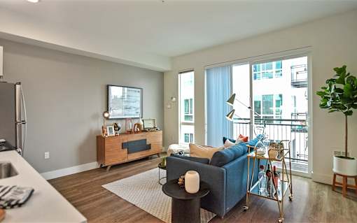 A living room with a blue couch and a wooden cabinet.