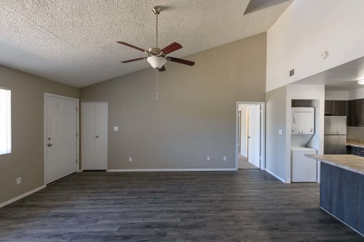a empty living room with a ceiling fan