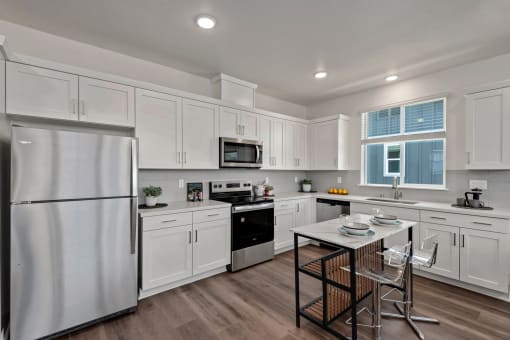 a kitchen with white cabinets and a table with chairs
