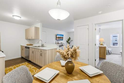 A modern kitchen with a dining table set for two.