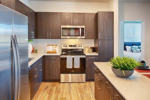 A modern kitchen with wooden cabinets and stainless steel appliances.