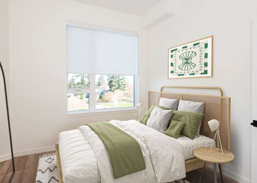 Arts Plaza Gresham Oregon Apartments A bedroom with a large bed and a green throw pillow.