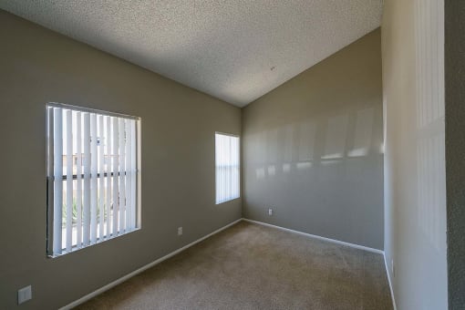 an empty living room with a large window and carpet