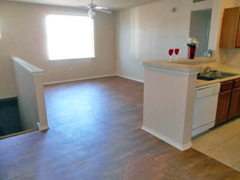 an empty kitchen and living room with a wood floor