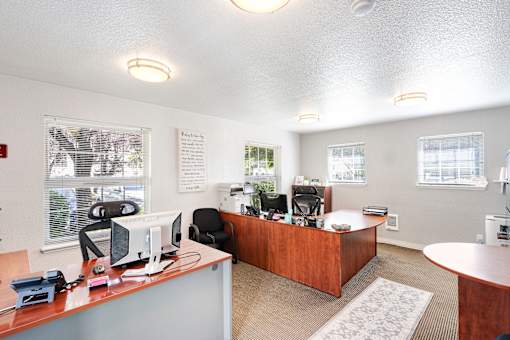 A white room with a desk and chairs.