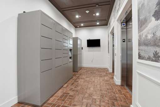 A hallway with a brick floor and a wall with a painting on it.
