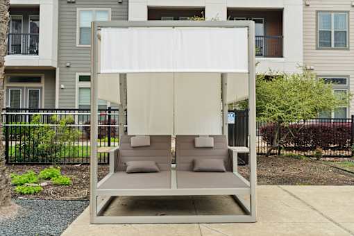 A white canopy is over a grey couch.