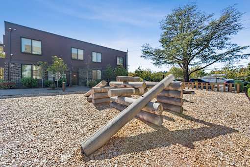 A playground with a seesaw in front of a building.