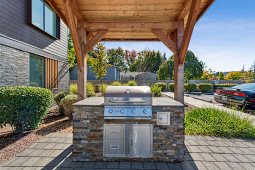 A modern outdoor kitchen with a grill and sink.