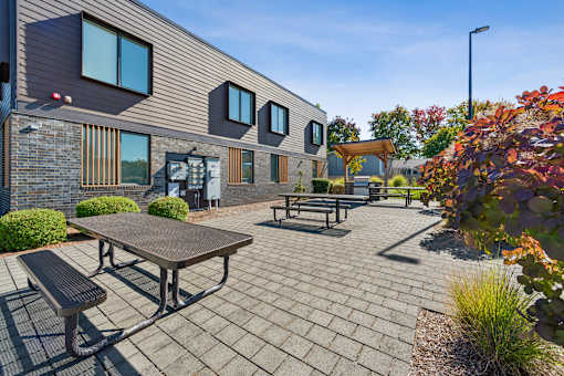 A modern building with a patio and picnic table.