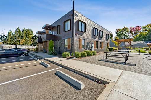 A modern building with a parking lot in front.