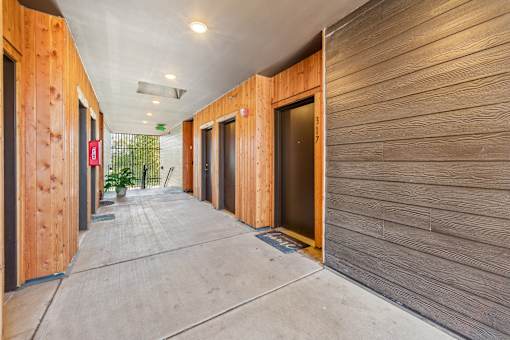 A long hallway with wooden walls and doors.