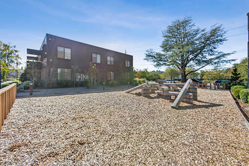 A playground area in front of a modern building.