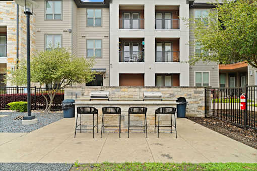 A patio with a table and chairs is in front of a building.