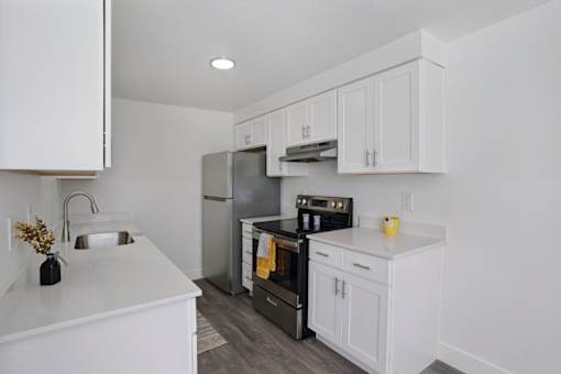 A kitchen with white cabinets and appliances.