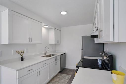 A kitchen with white cabinets and a black stove top oven.