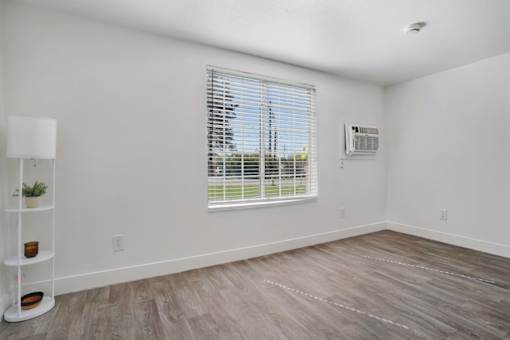 A room with a window and a floor lamp.