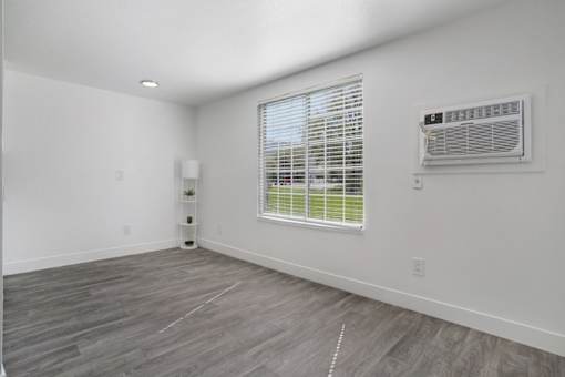 A room with a window and a wall-mounted air conditioner unit.