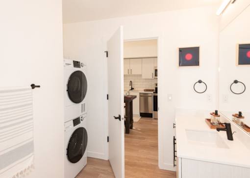 Arts Plaza Gresham Oregon Apartments A white laundry room with a washer and dryer stacked on top of each other.