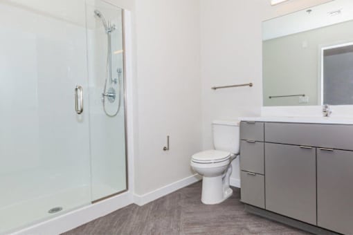 A white toilet sits in a bathroom next to a walk-in shower.