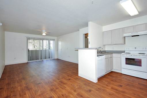 A large empty room with wooden floors and white walls.