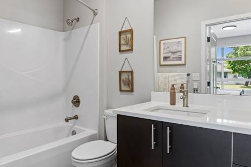 A white bathroom with a toilet, sink, and shower.