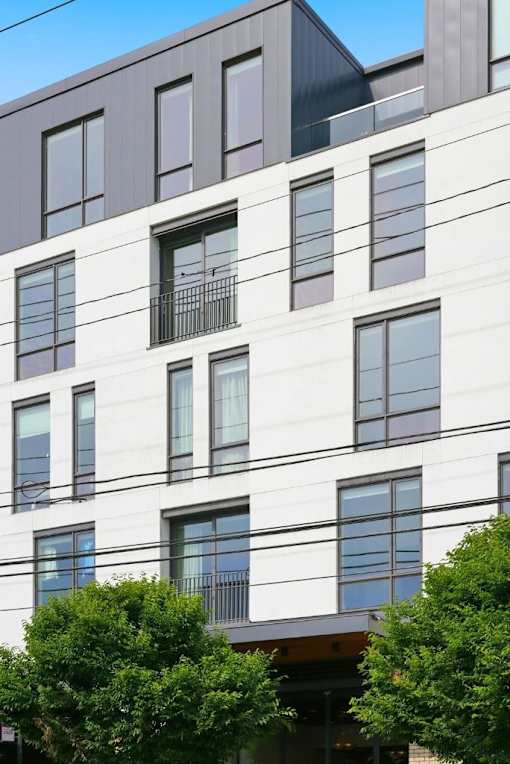 A modern building with white walls and dark windows.