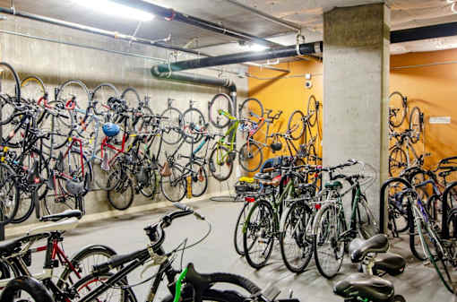 A bike rack full of bicycles in a parking garage.