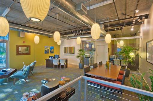 A modern office space with yellow walls and a glass railing.