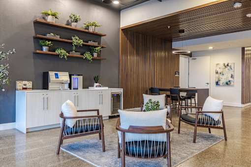 A modern waiting room with wooden furniture and a reception desk.