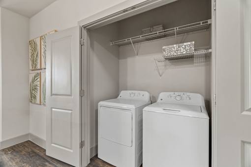 A laundry room with two washing machines and a dryer.
