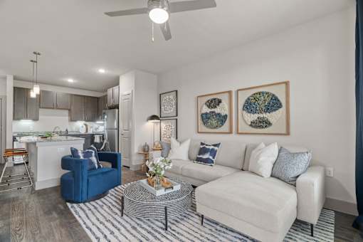 A living room with a blue chair and a white couch.