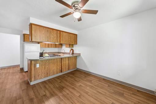 A kitchen with a wooden counter and a ceiling fan.