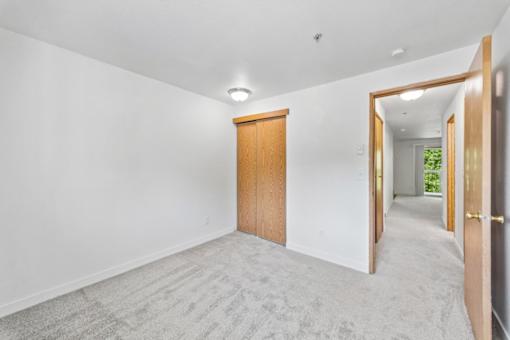 A room with a carpeted floor and a wooden door.