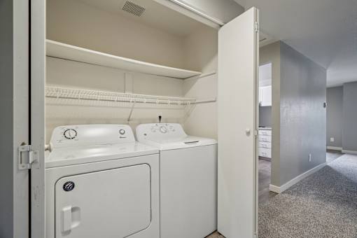 A white dryer and washer are in a small laundry room.